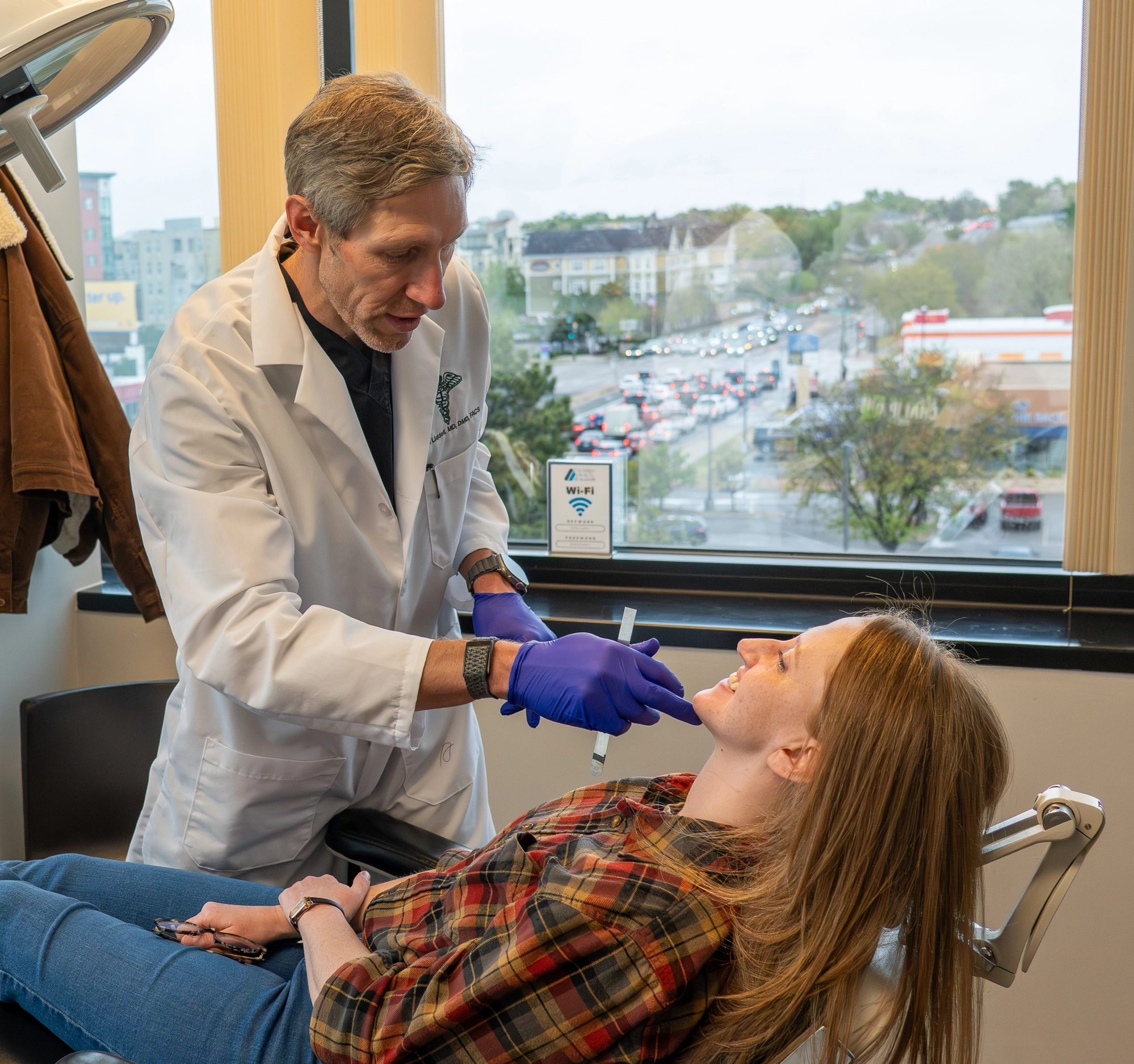 Doctor examining patient for wisdom teeth at Colorado Oral Surgery
