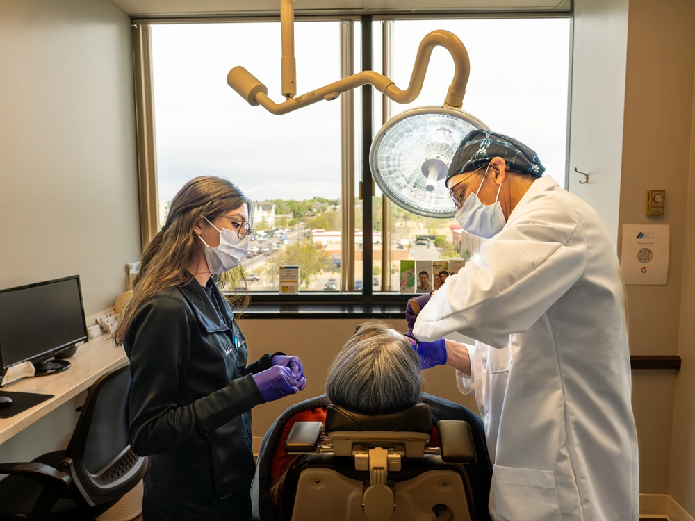 Doctor and assistant performing dental implant procedure at Colorado Oral Surgery