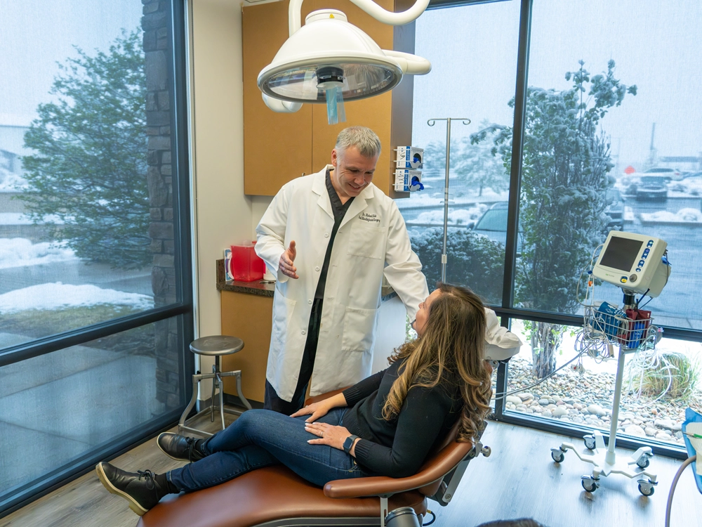 Doctor consulting with patient in treatment room at Colorado Oral Surgery