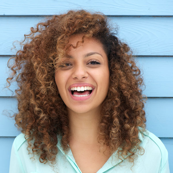 woman smiling against blue wood background